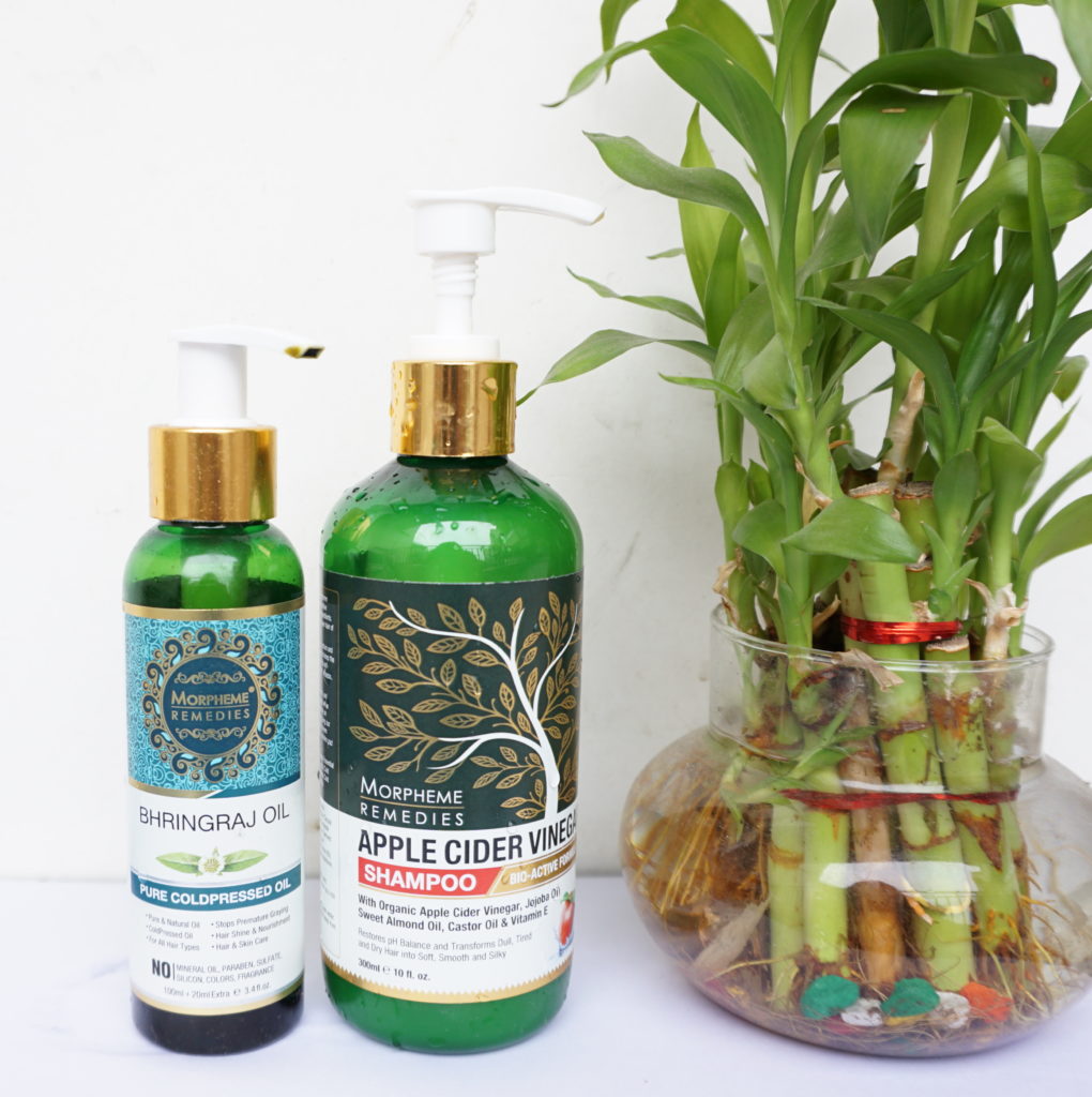 Morphme remedies brahmi hair oil and apple cider vinegar shampoo with a table plant