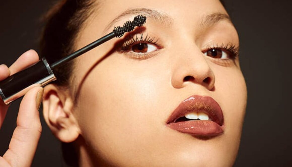 asian woman applying makeup for valentine's day