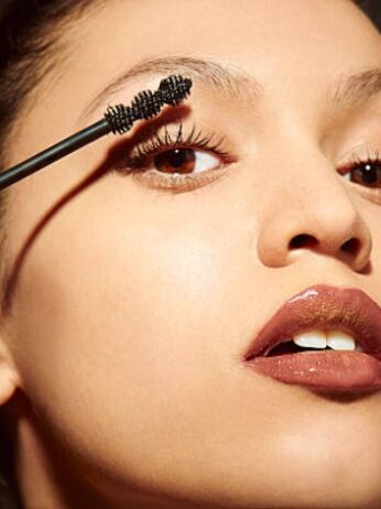 asian woman applying makeup for valentine's day