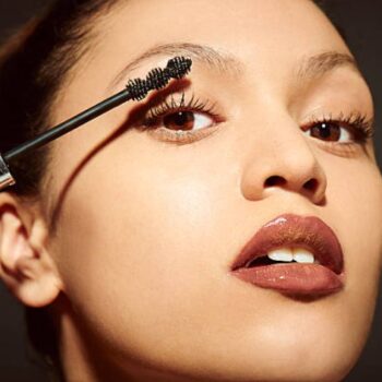 asian woman applying makeup for valentine's day