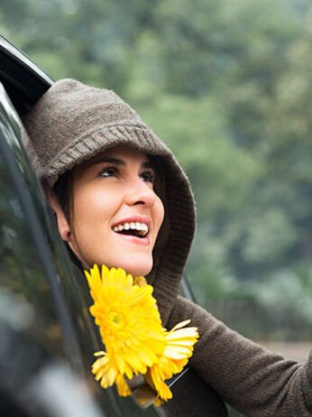 Woman looking out from car window in rain