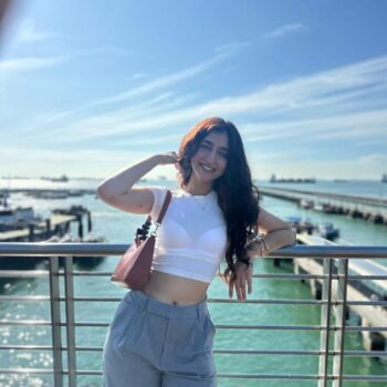 chavi khattar standing by the pool side in dubai in white top grey pants