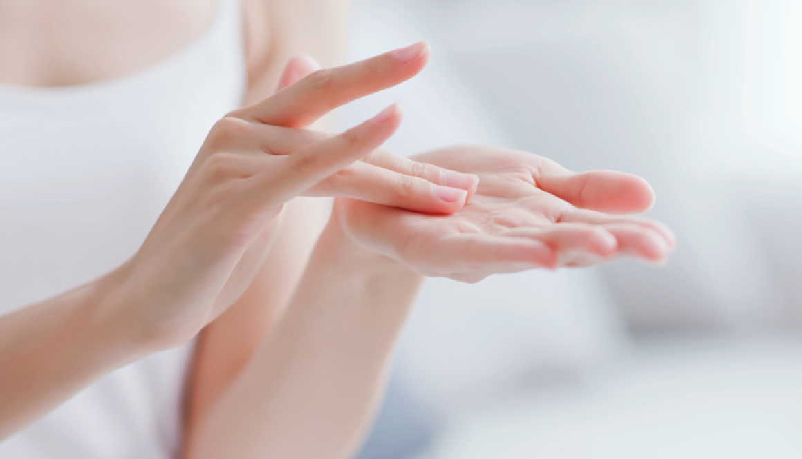 Close-up of hands applying moisturizer, demonstrating proper skincare technique.