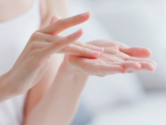 Close-up of hands applying moisturizer, demonstrating proper skincare technique.