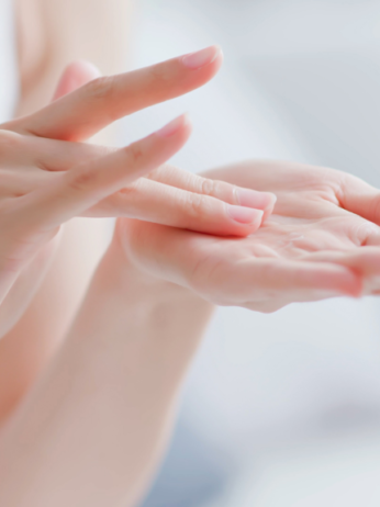 Close-up of hands applying moisturizer, demonstrating proper skincare technique.