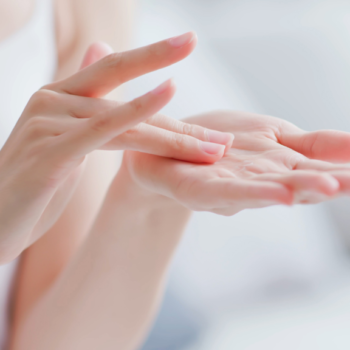 Close-up of hands applying moisturizer, demonstrating proper skincare technique.