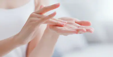 Close-up of hands applying moisturizer, demonstrating proper skincare technique.